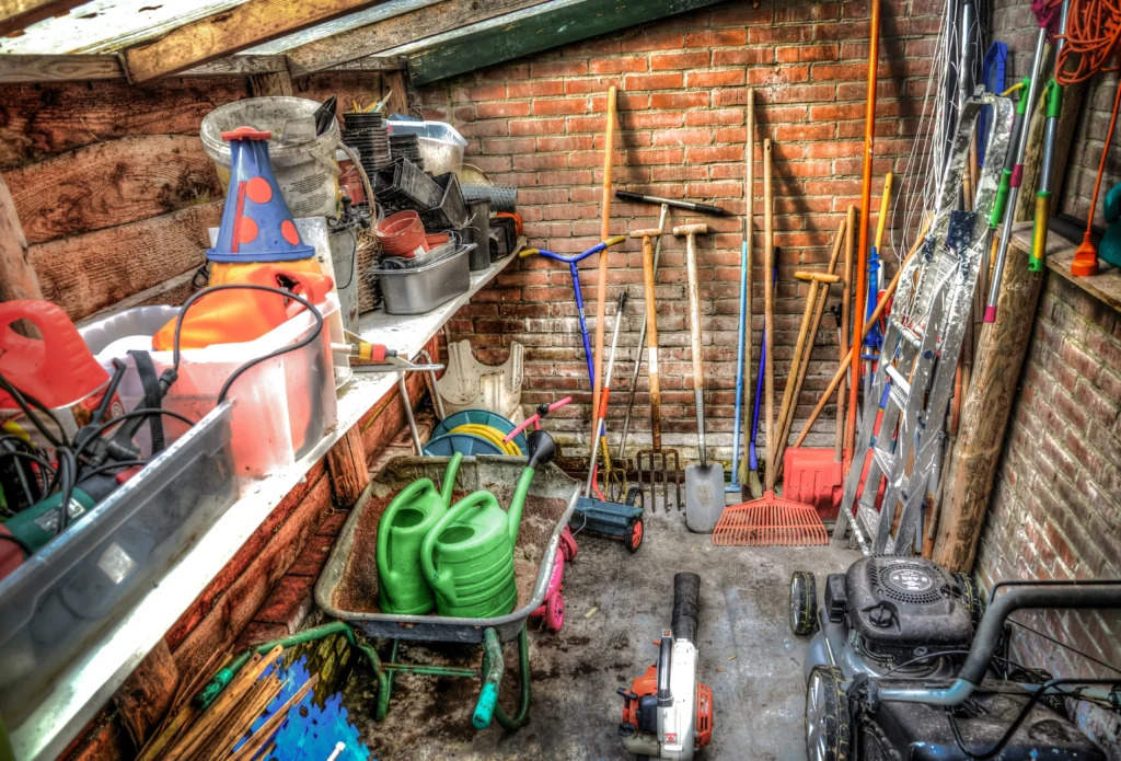 Garden tools and equipment stored inside a domestic shed.